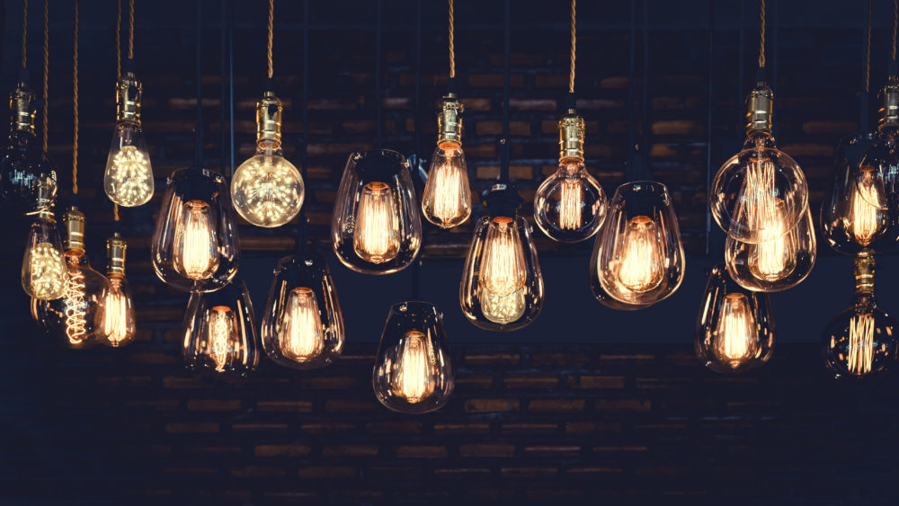 Beautiful vintage luxury light bulb hanging decor glowing in dark. Retro filter effect style.